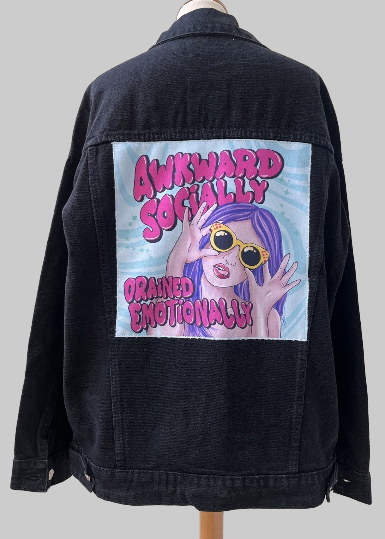Denim jacket with handmade fabric patch artwork on back
