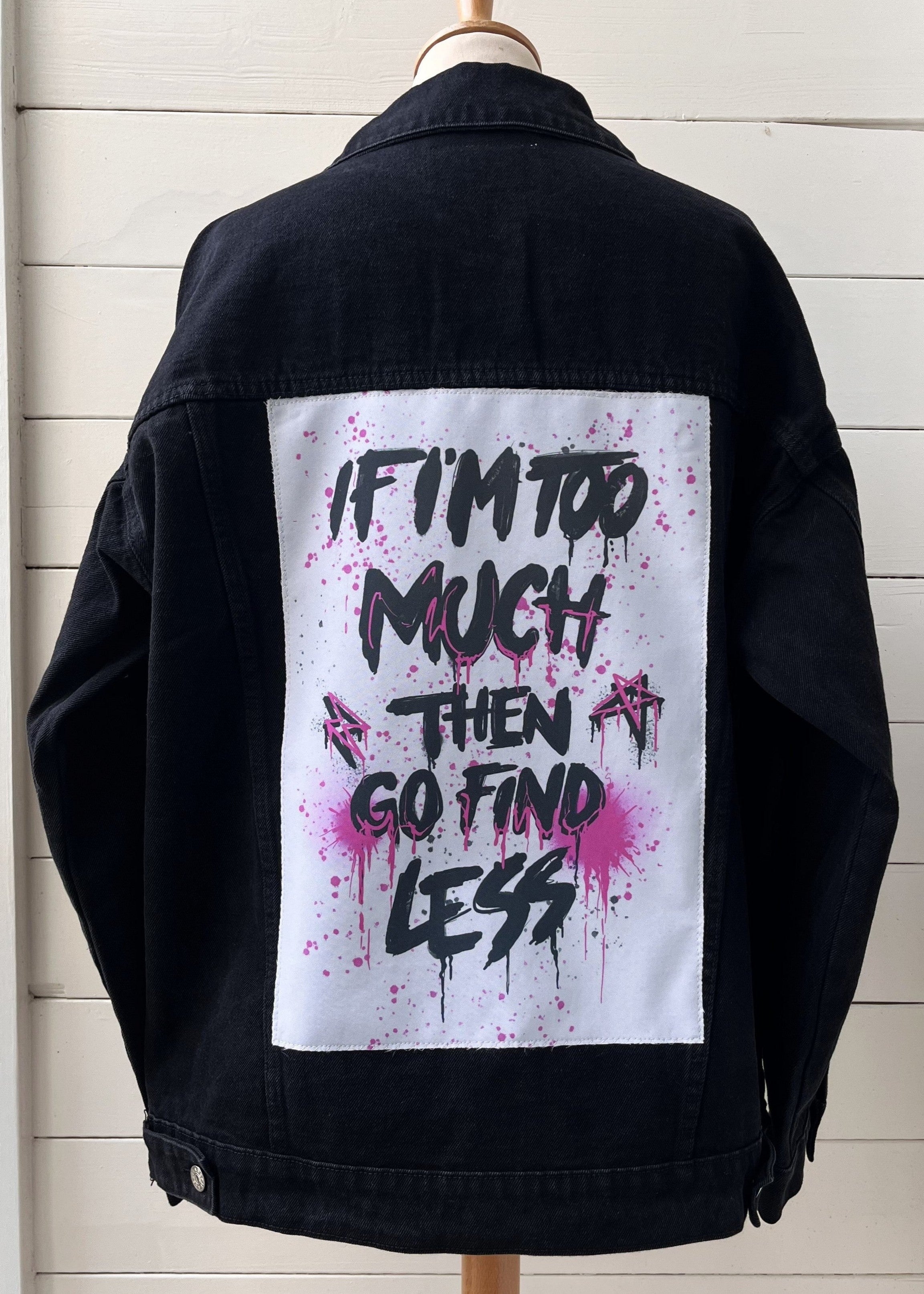 Black jacket with a white patch featuring black text on a wooden background