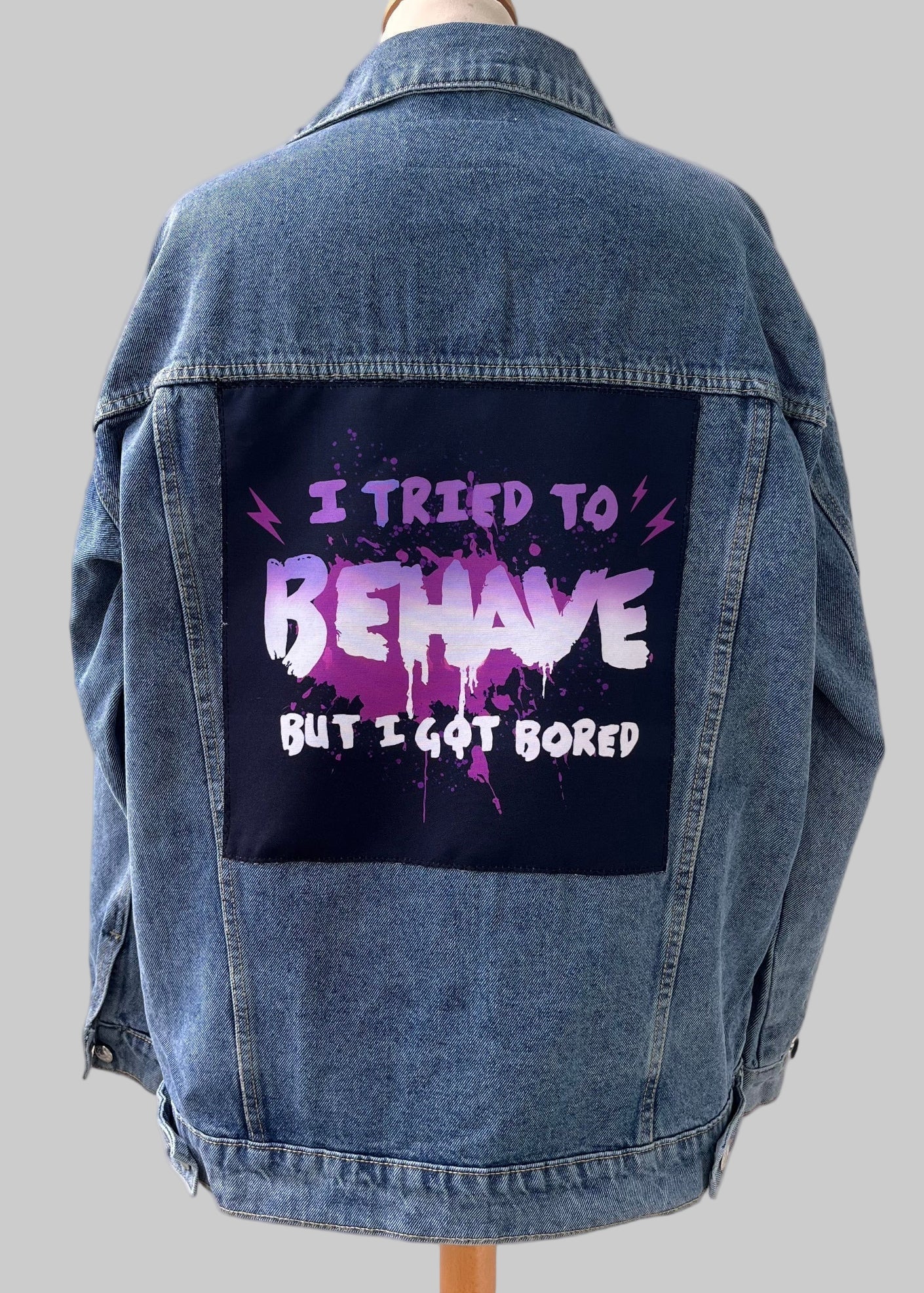 Denim jacket with handmade fabric patch artwork on back