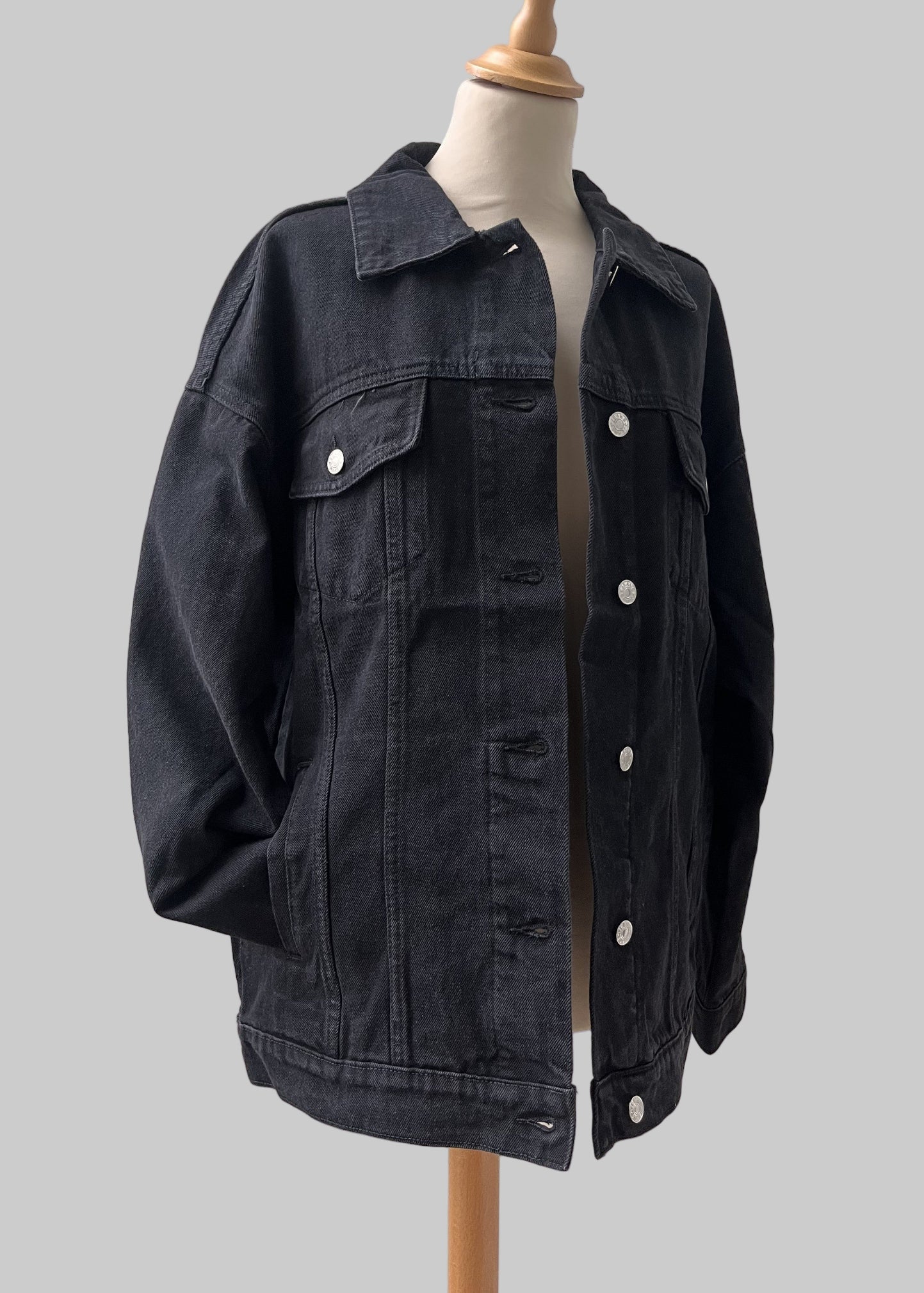 Artistic back design on medium-wash black denim jacket oversized