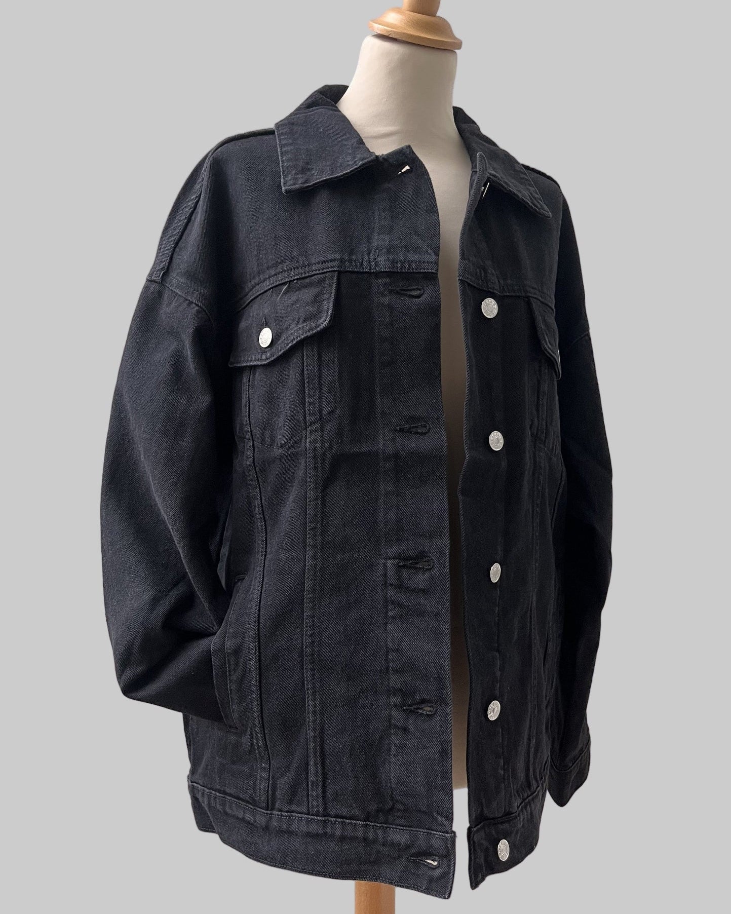 Artistic back design on medium-wash black denim jacket oversized