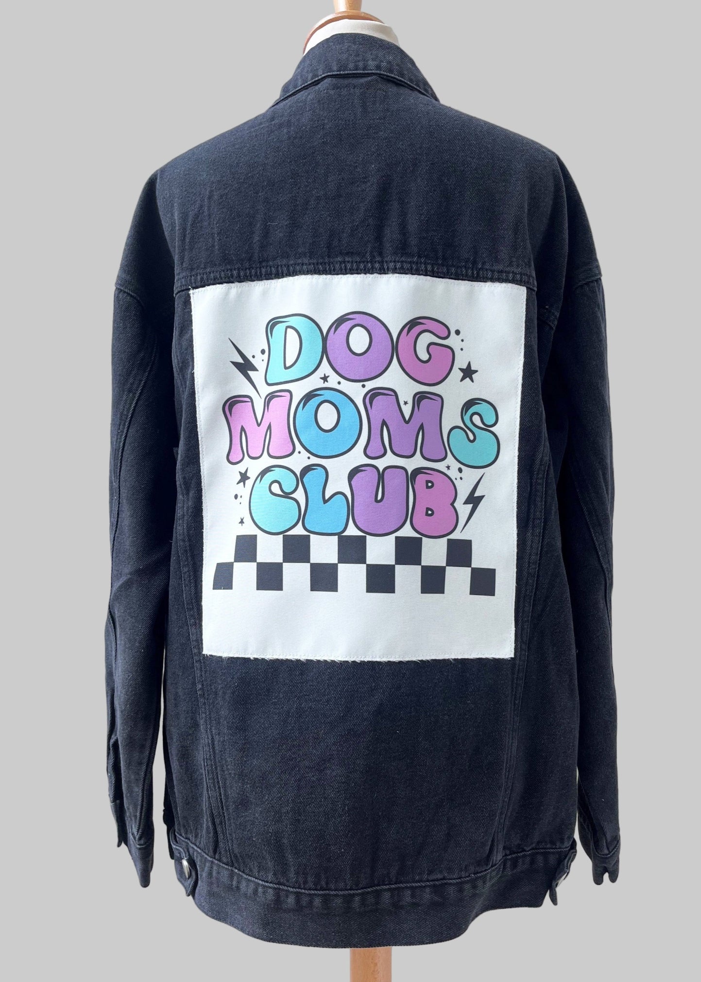 Black denim jacket with 'Dog Moms Club' graphic on a white background