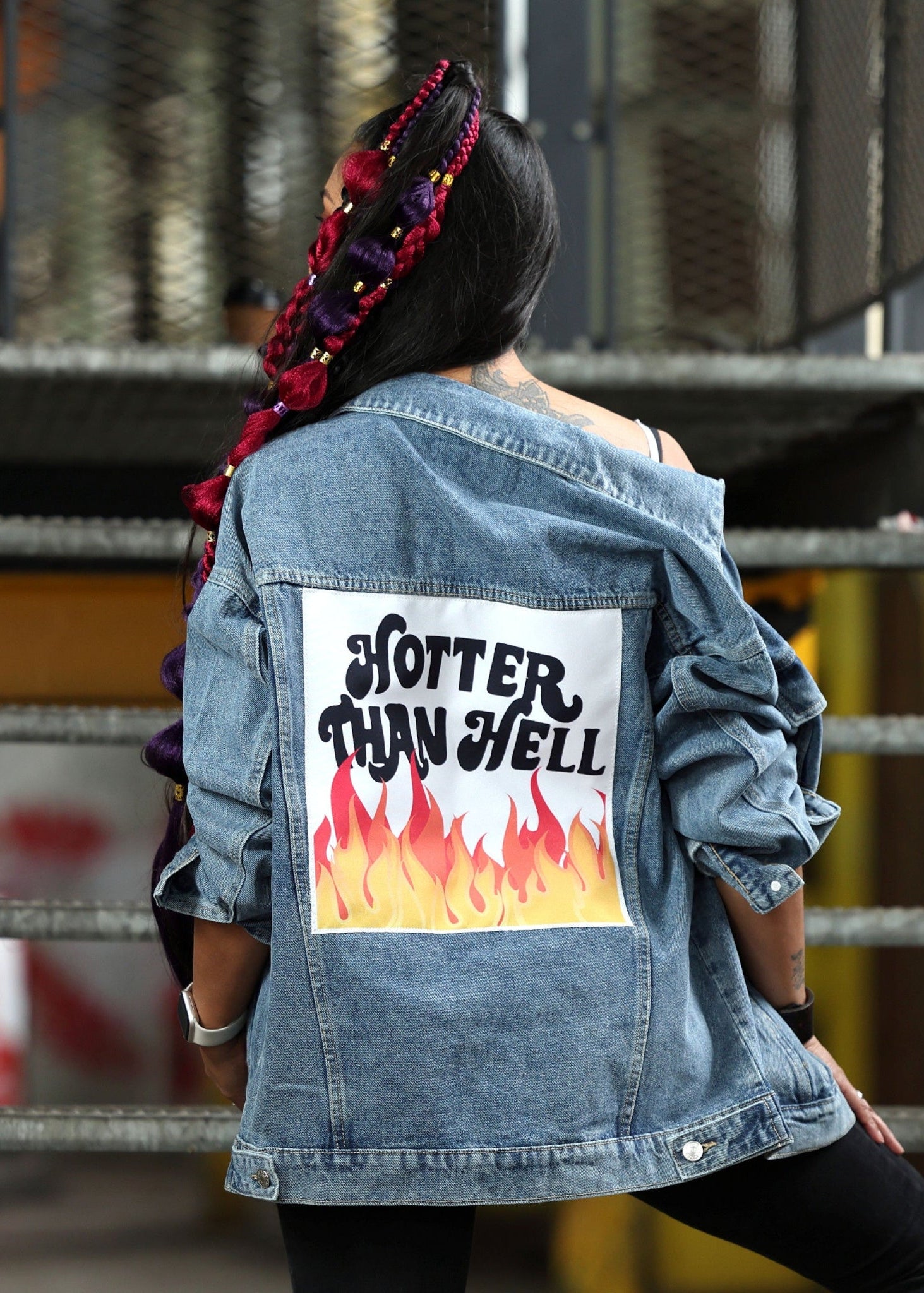 Person wearing a denim jacket with 'Hotter Than Hell' graphic on the back.