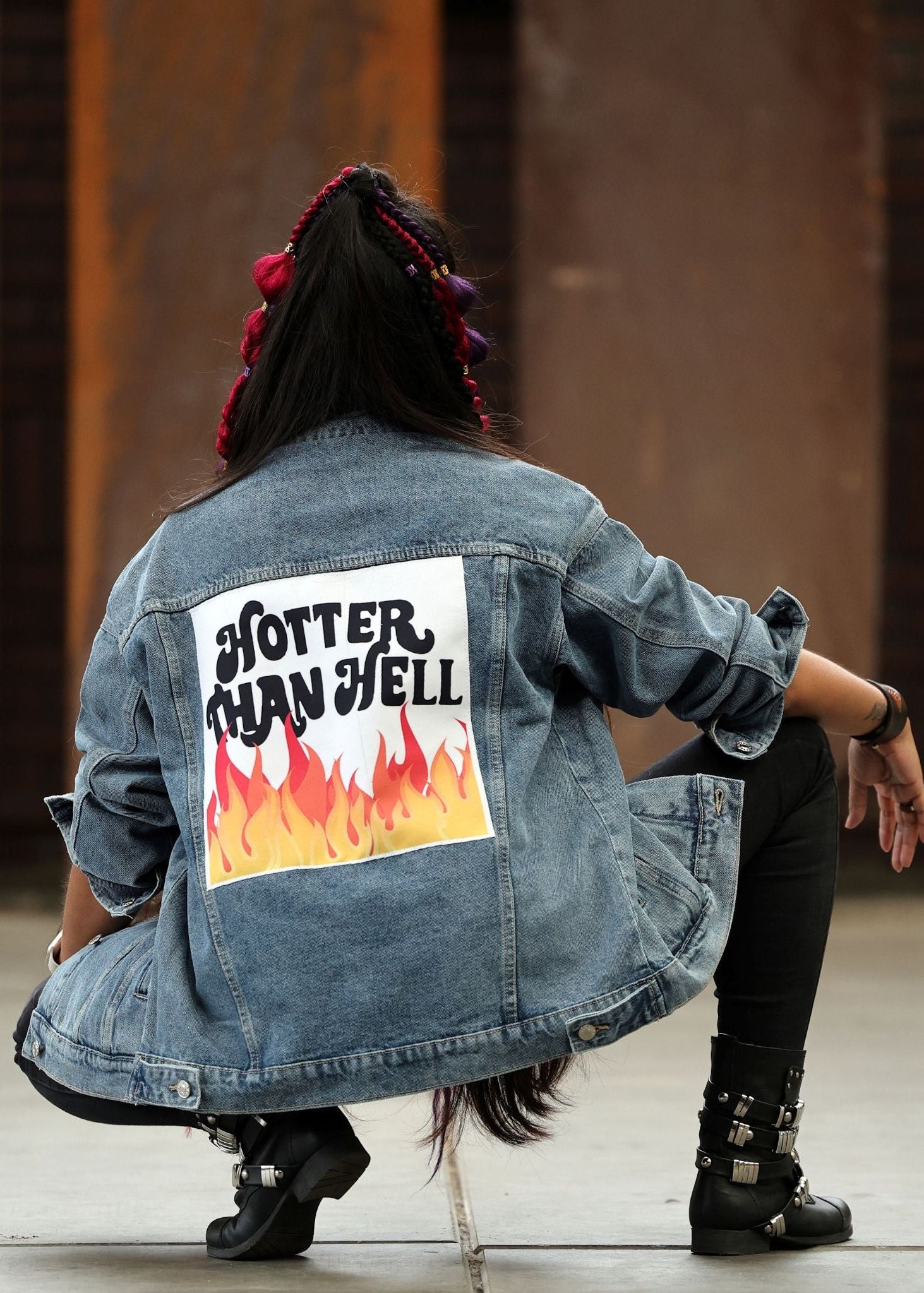 Person wearing a denim jacket with 'Hotter Than Hell' graphic on the back.