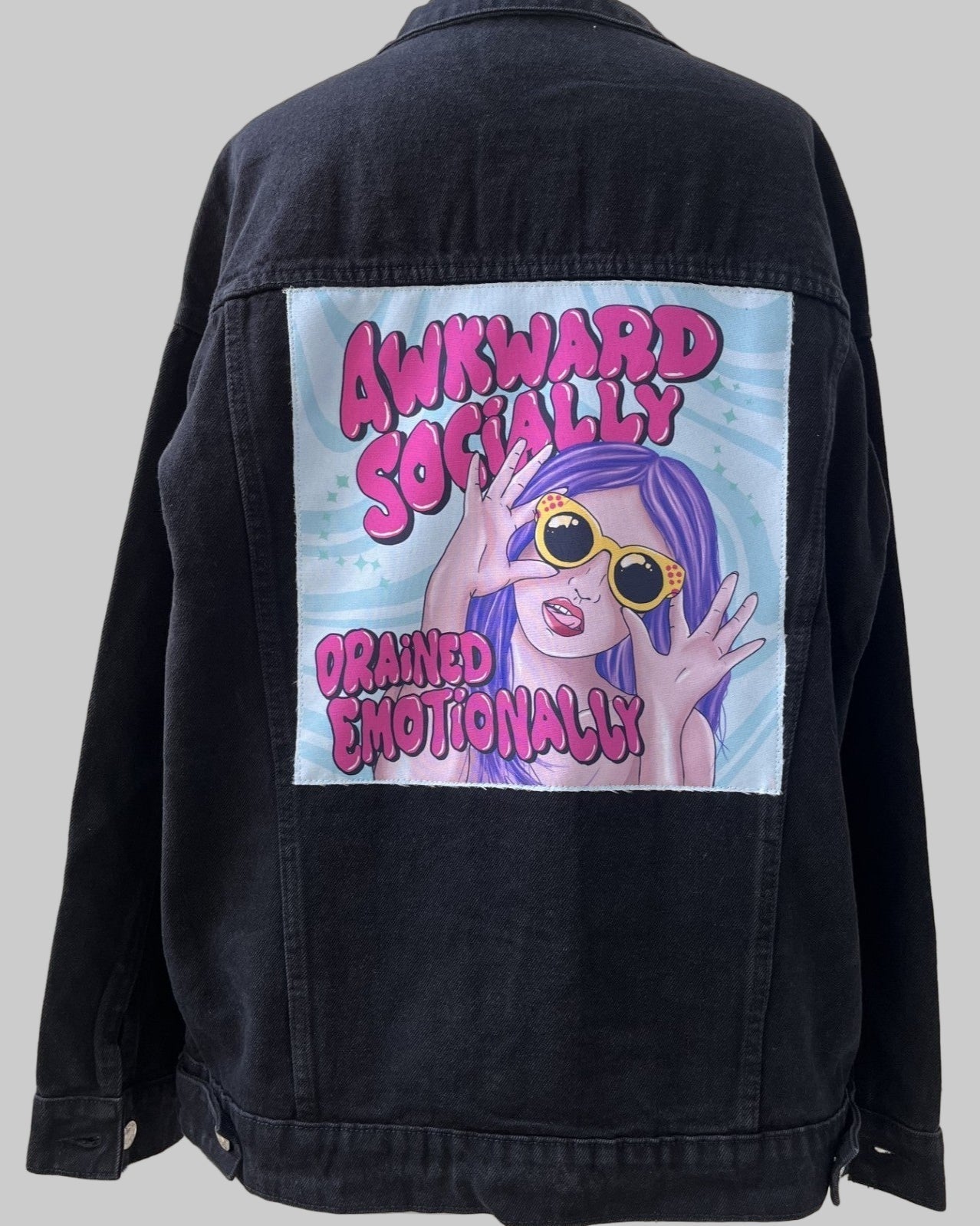 Denim jacket with handmade fabric patch artwork on back