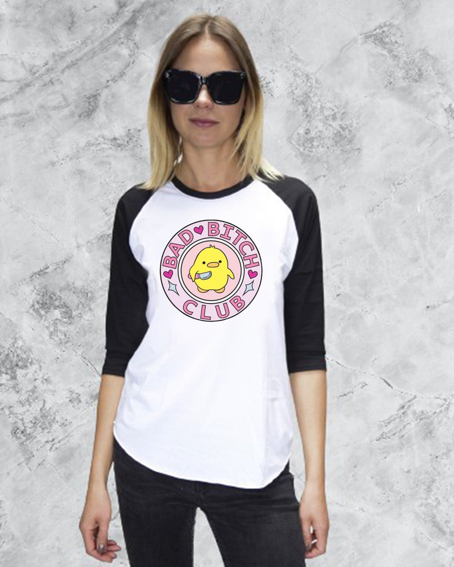 Woman wearing a black and white baseball shirt with a graphic design on a gray background