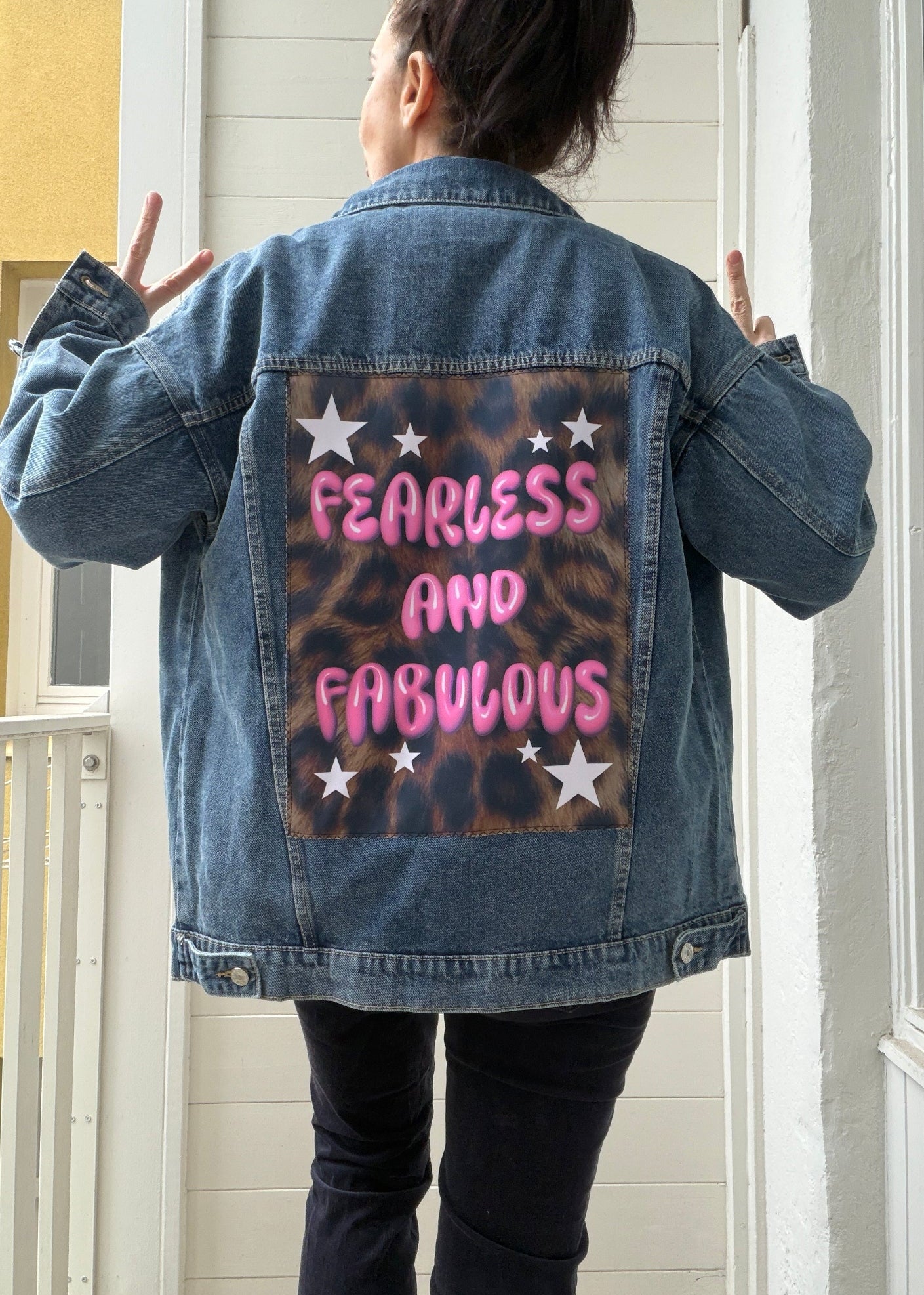 Person wearing a denim jacket with 'Fearless and Fabulous' text on the back