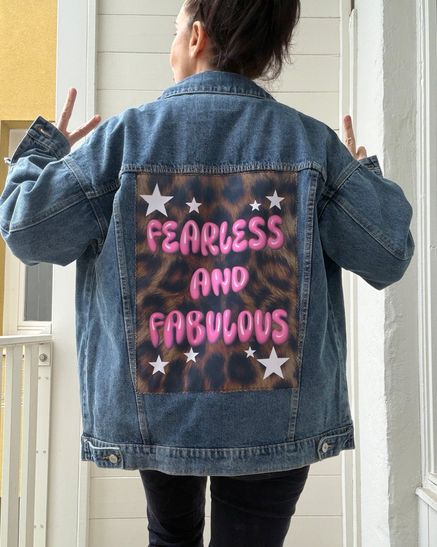 Person wearing a denim jacket with 'Fearless and Fabulous' text on the back