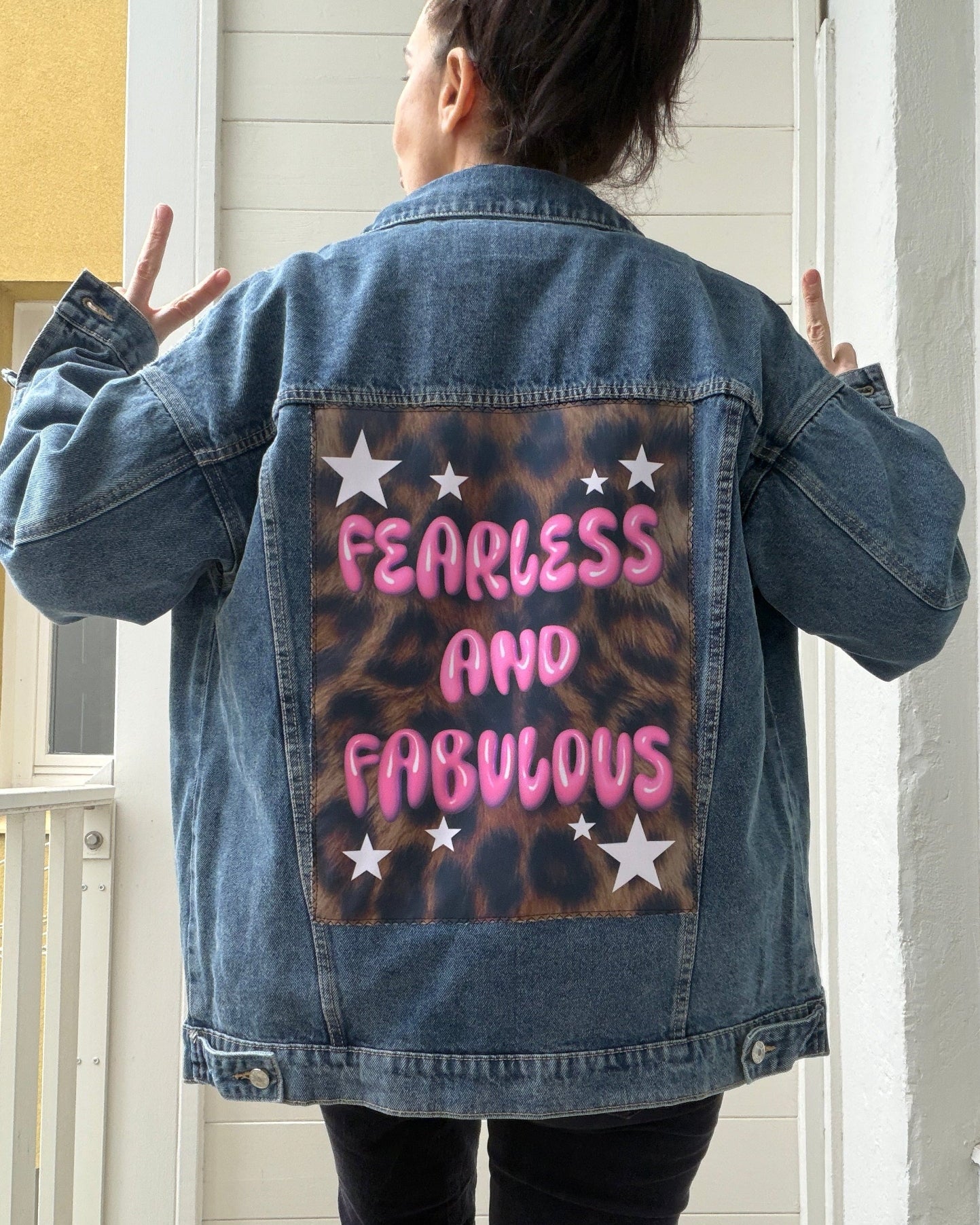 Person wearing a denim jacket with 'Fearless and Fabulous' text on the back