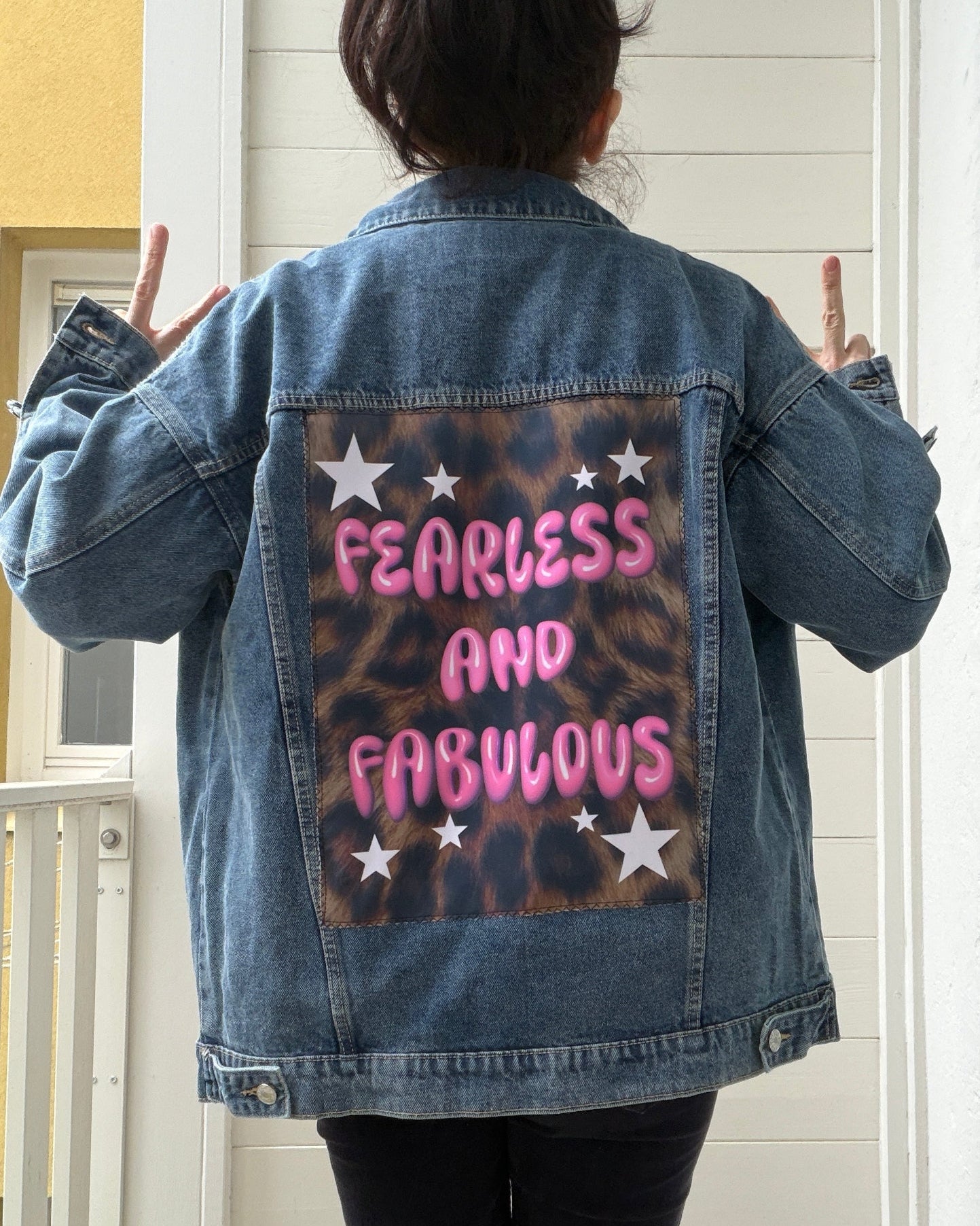 Person wearing a denim jacket with 'Fearless and Fabulous' text on the back
