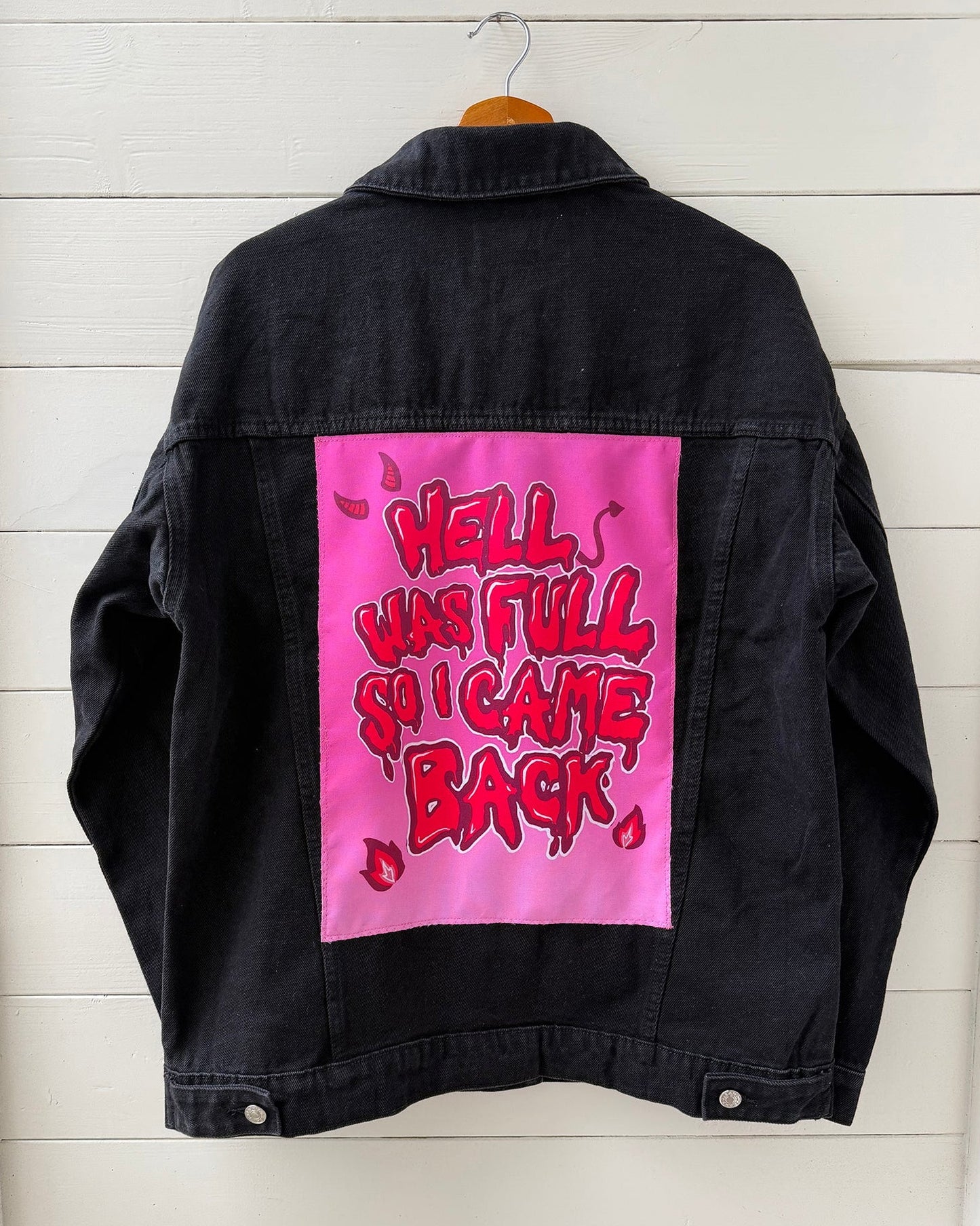 Black denim jacket with Hell Was Full So I Came Back pink and red digital art patch on back