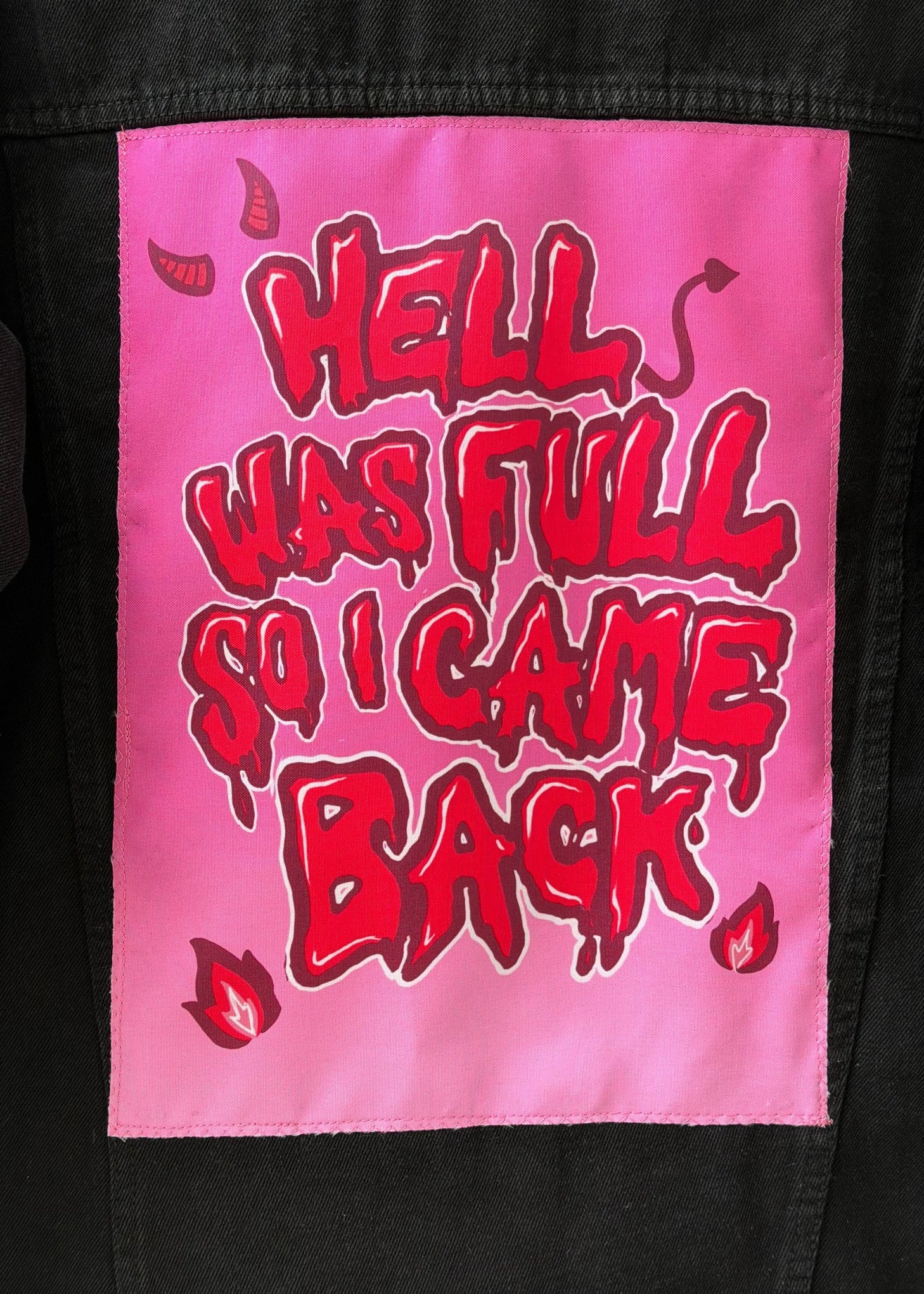 Pink patch with red text 'HELL WAS FULL SO I CAME BACK' on a black background