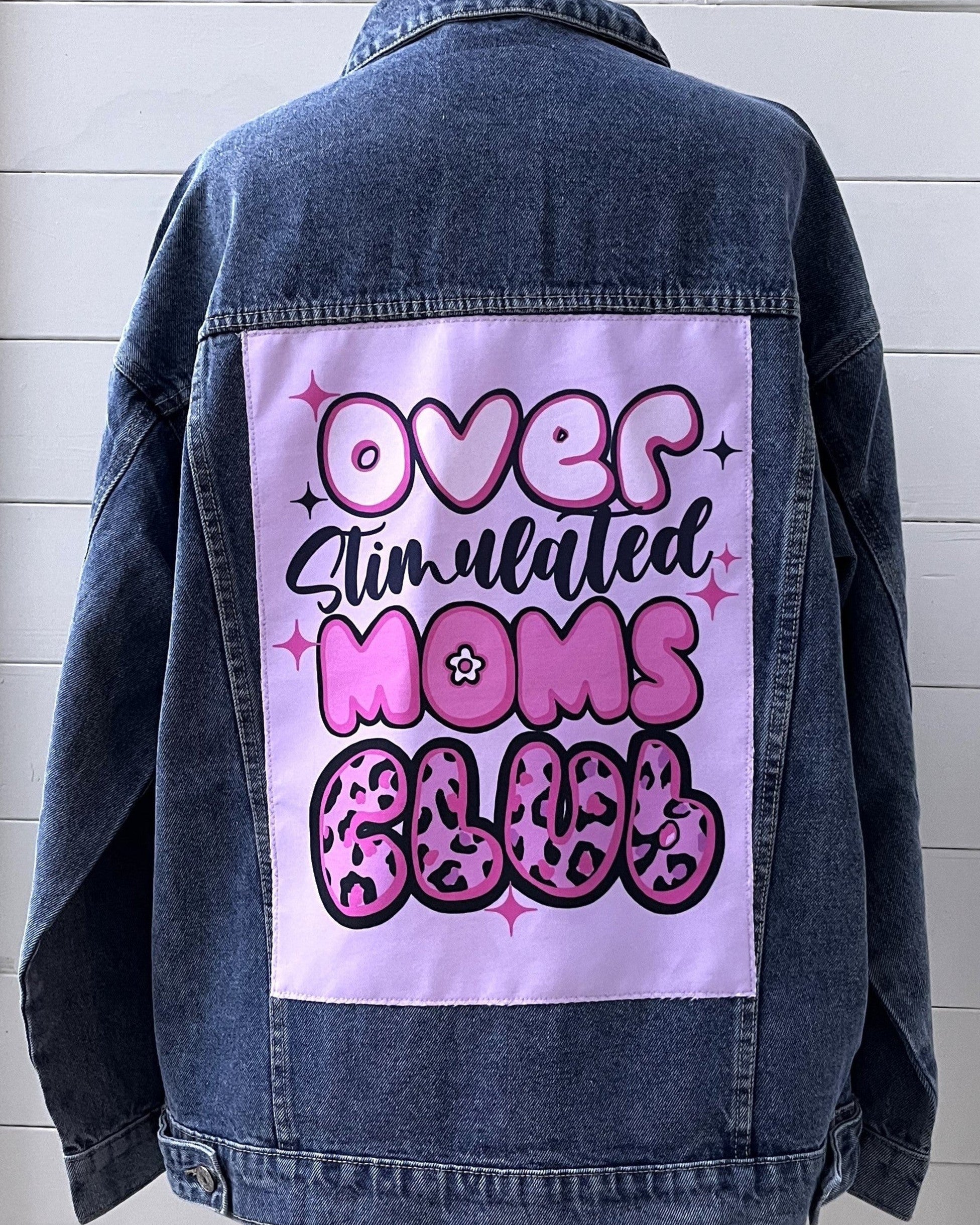 Denim jacket with a graphic design on the back against a white background