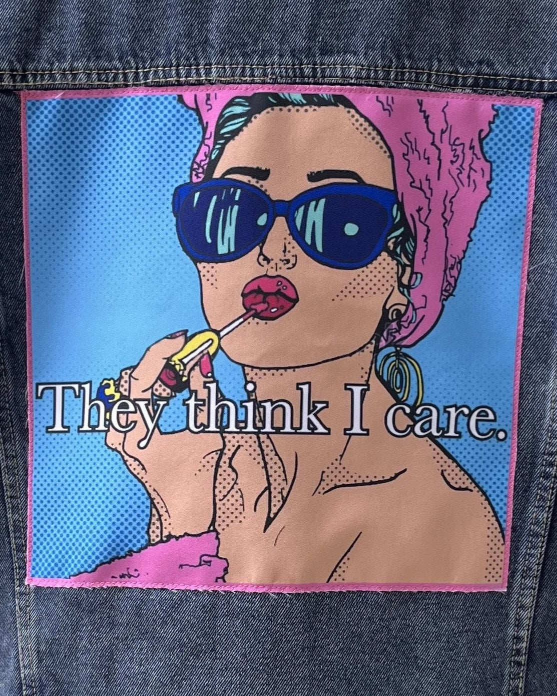 Patch on a denim jacket with a stylized illustration of a woman and text 'They think I care'.