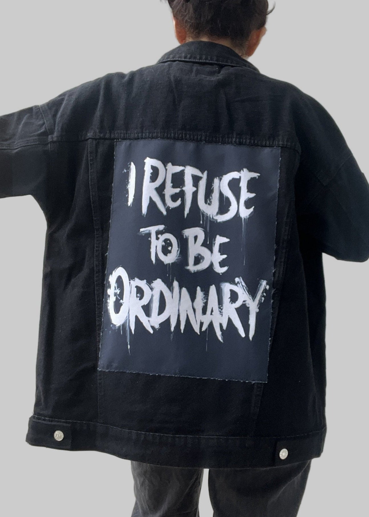 Denim jacket with handmade fabric patch artwork on back