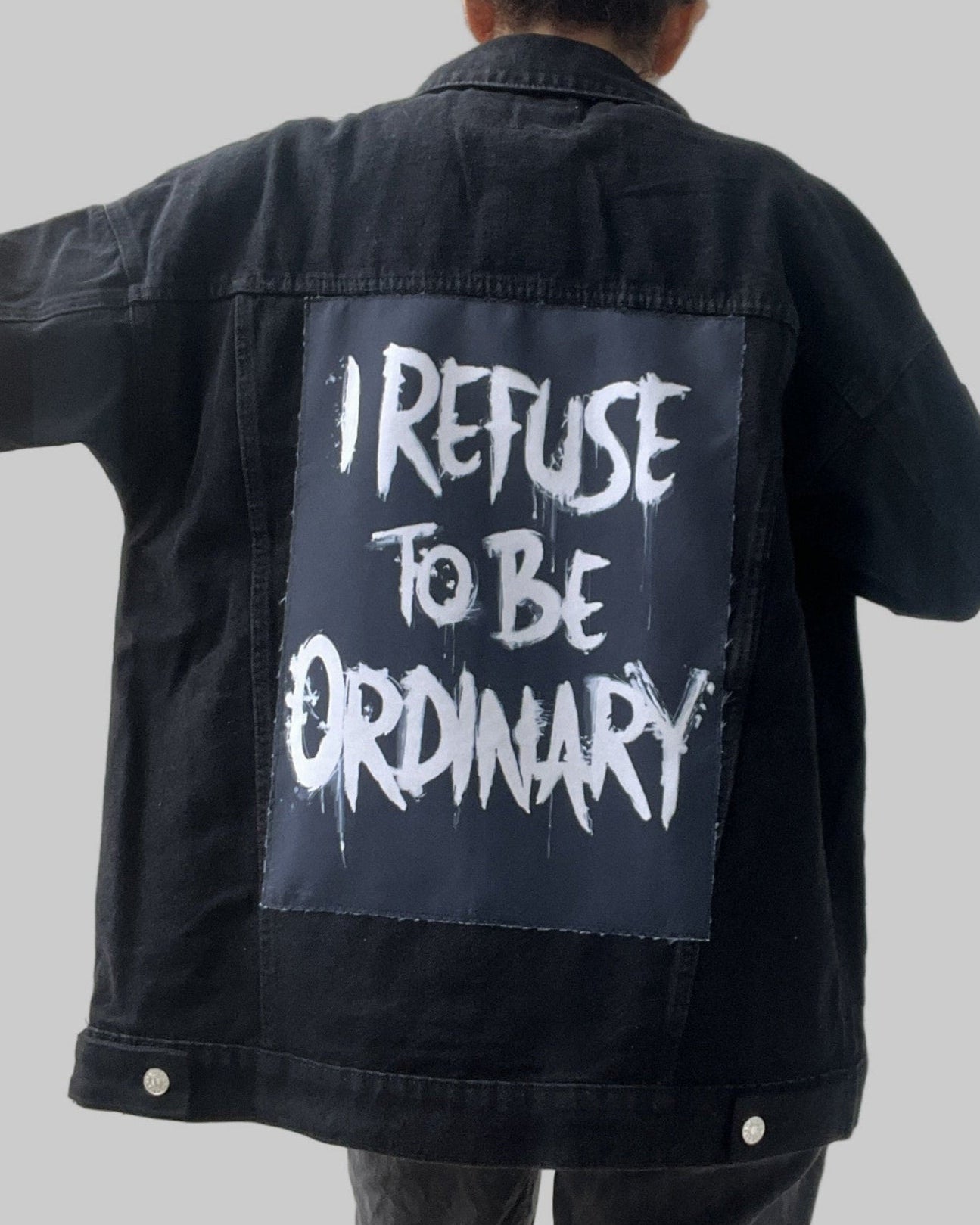 Denim jacket with handmade fabric patch artwork on back