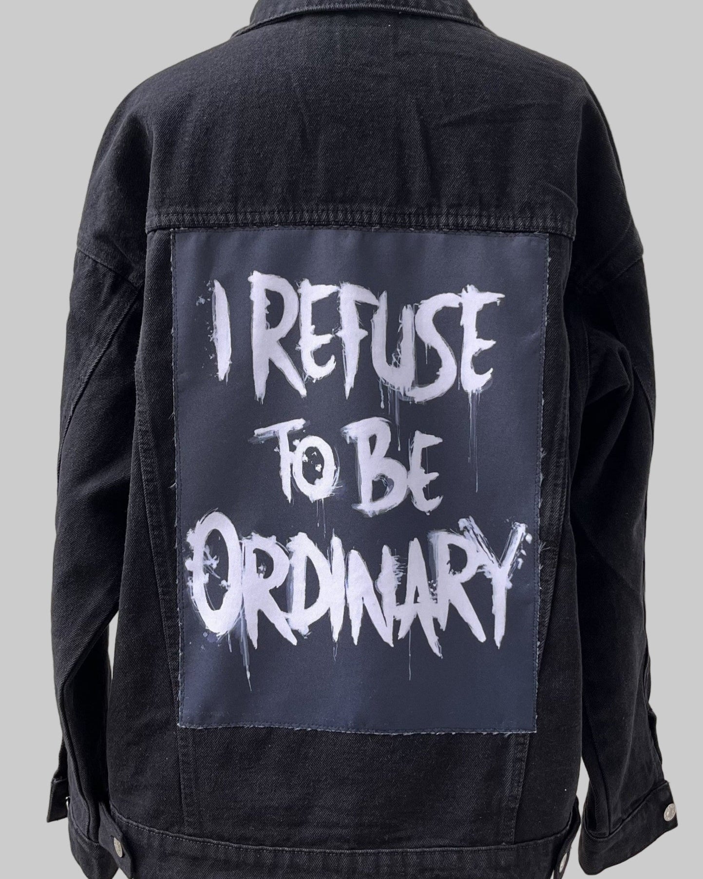 Denim jacket with handmade fabric patch artwork on back