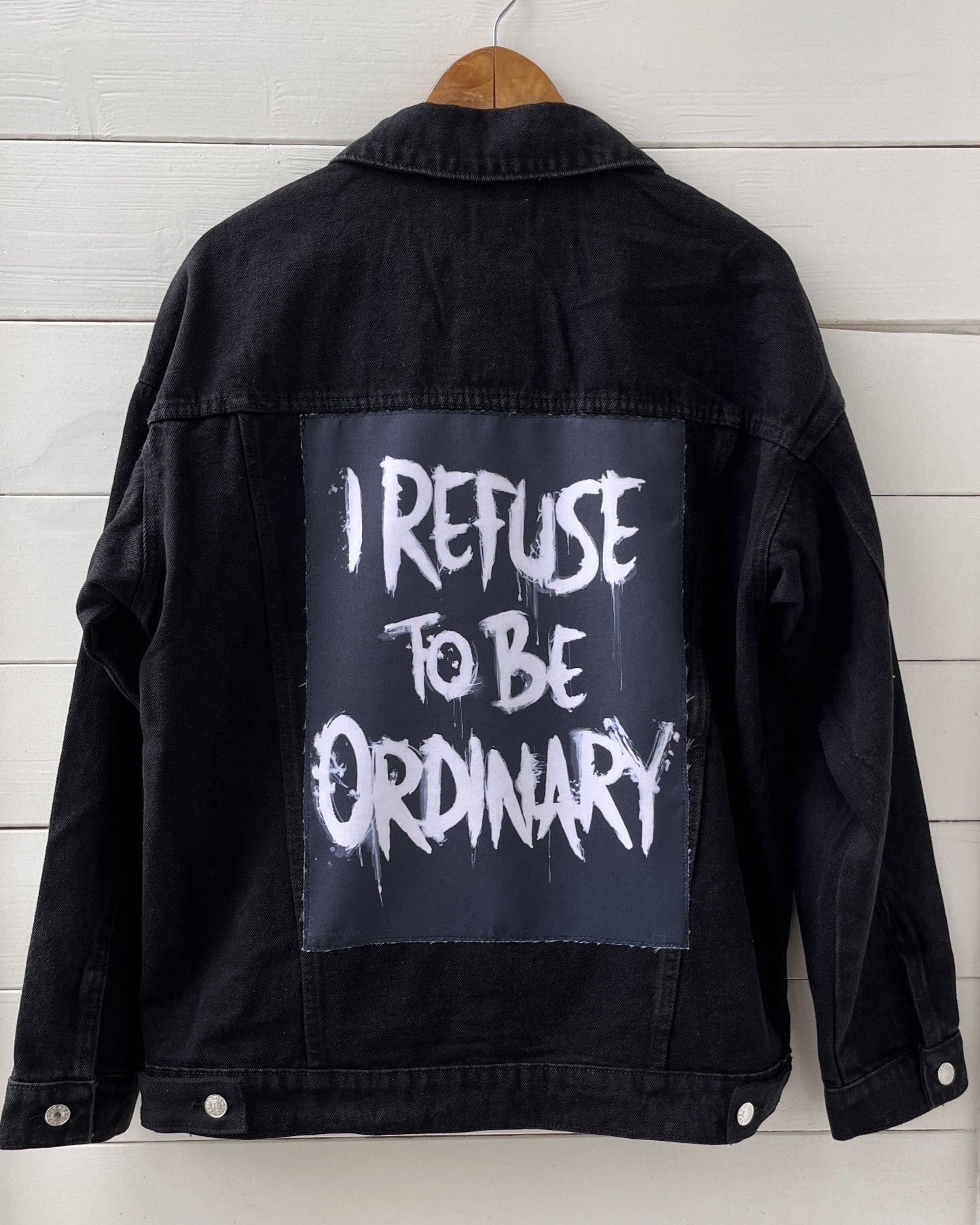 Denim jacket with handmade fabric patch artwork on back