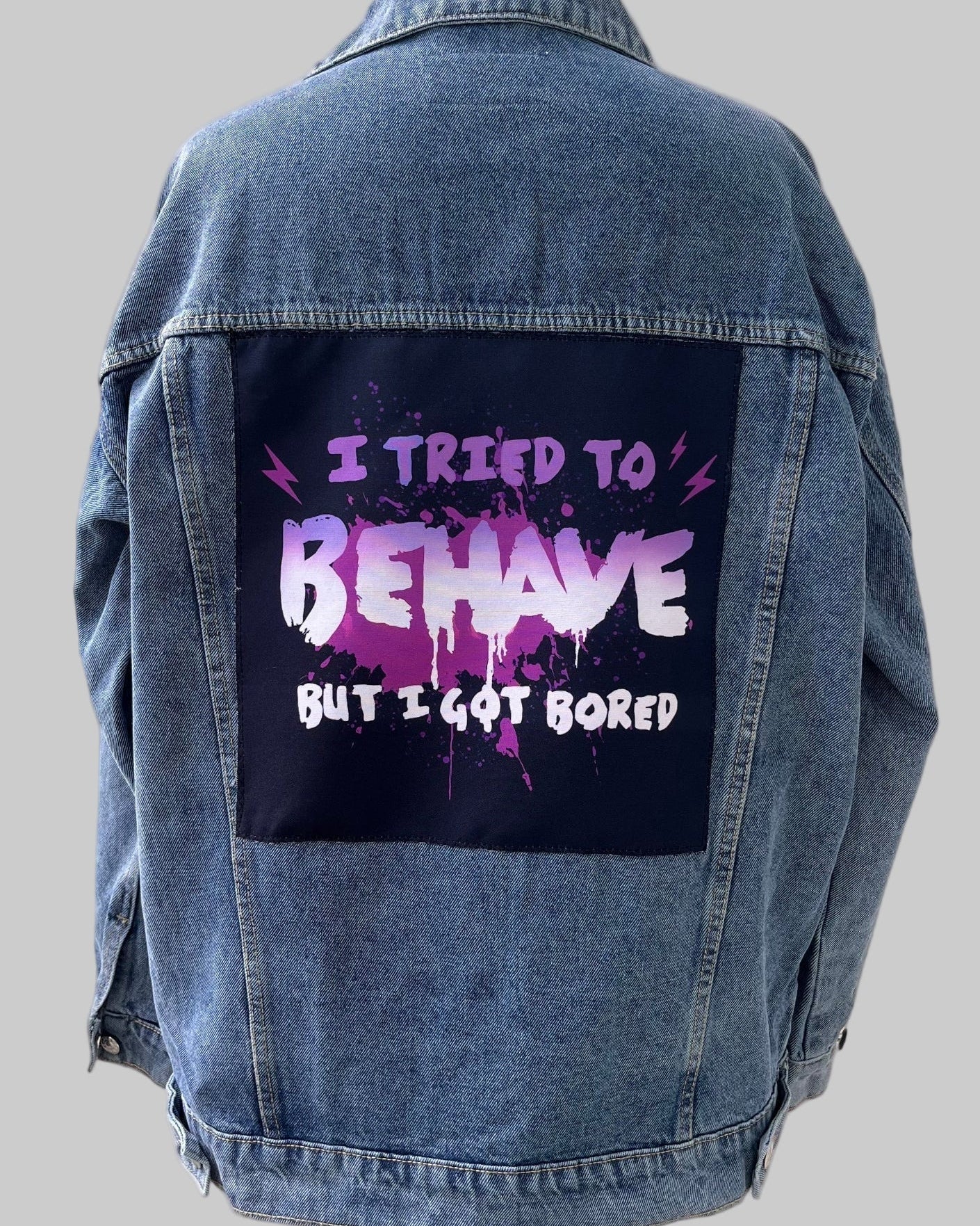 Denim jacket with handmade fabric patch artwork on back