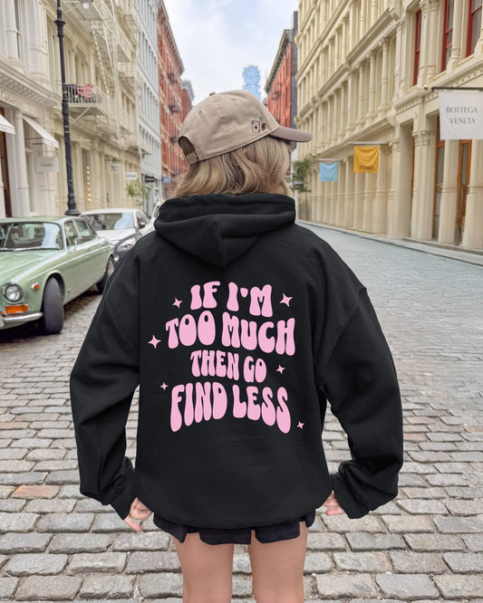 Person wearing a black hoodie with pink text on a city street