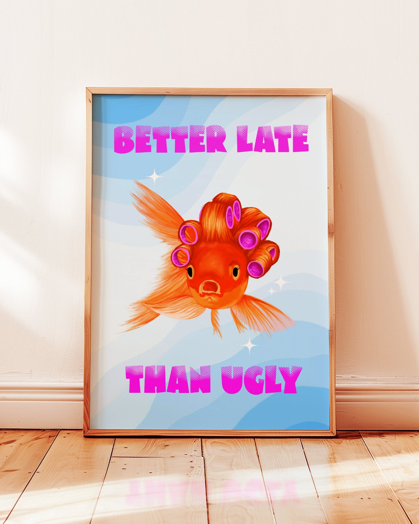Framed artwork with a fish wearing curlers and text 'Better Late Than Ugly' on a light background.