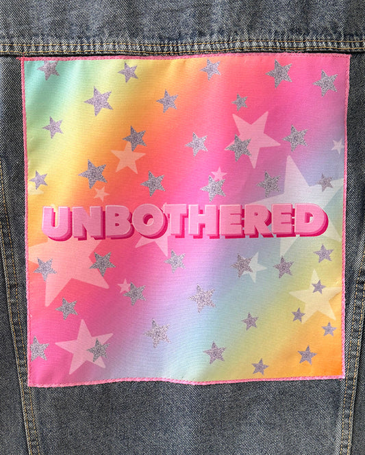 Colorful patch with 'UNBOtherED' text and star patterns on a denim background