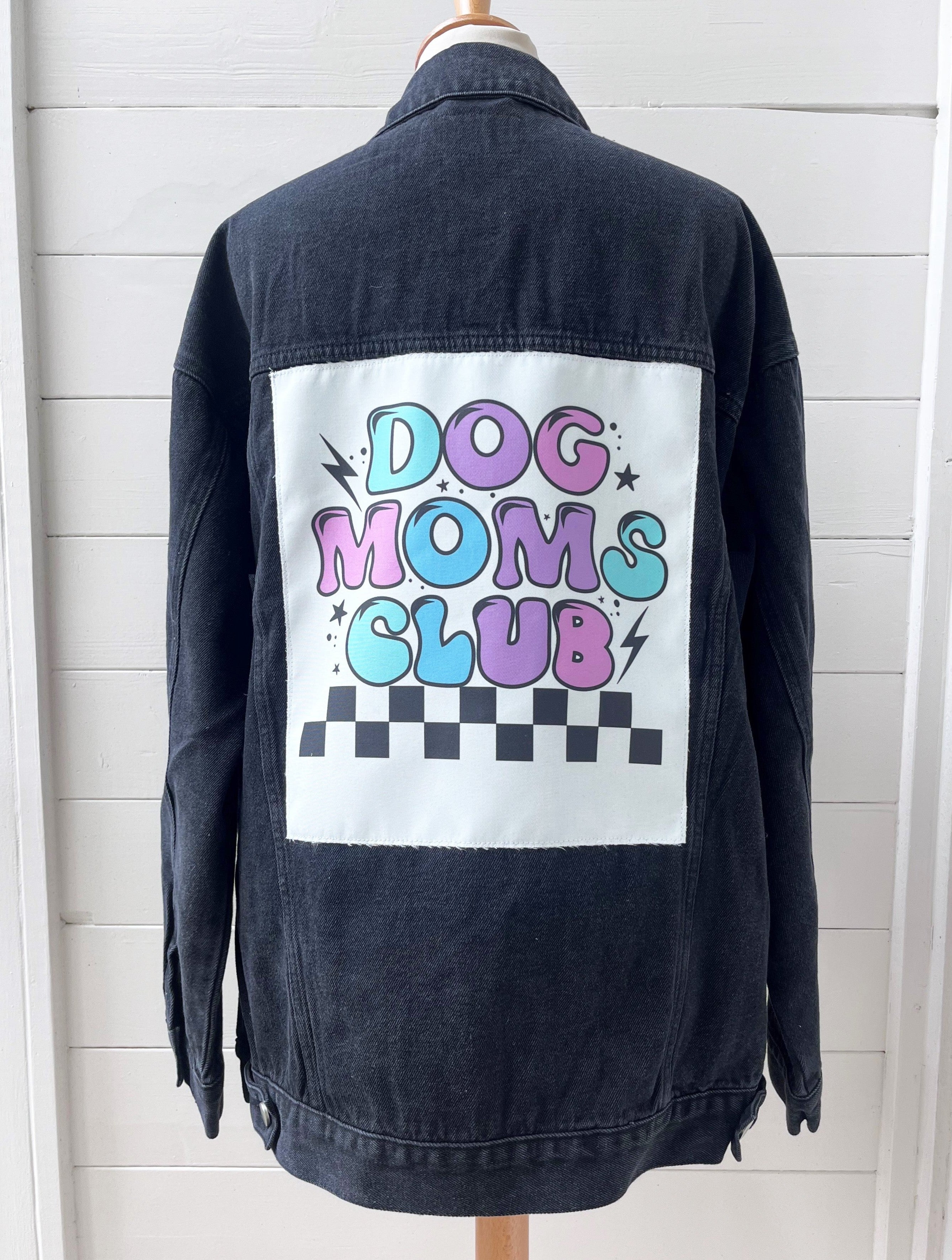 Black denim jacket with 'Dog Moms Club' graphic on a white background