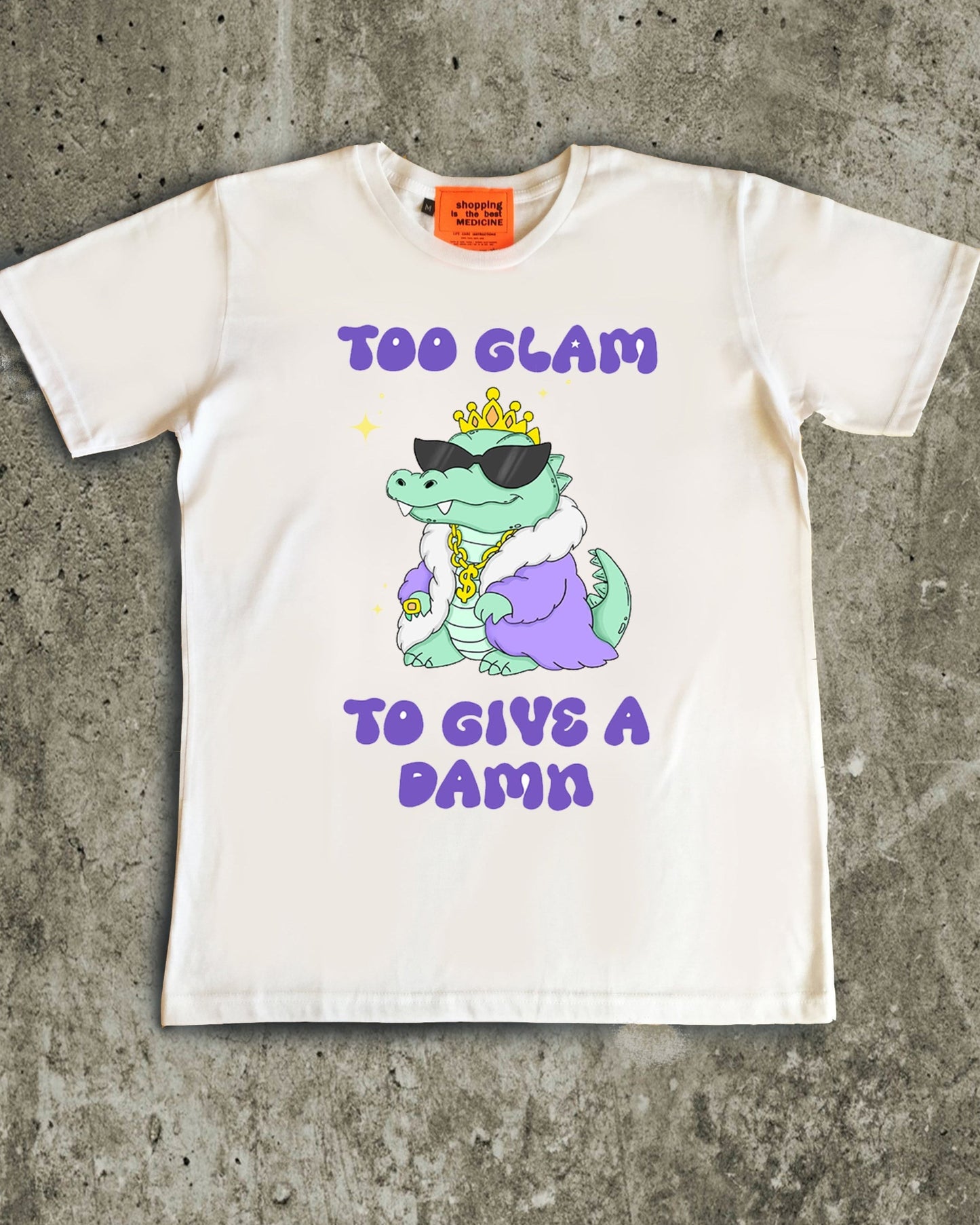 White t-shirt with a graphic of a dinosaur and text on a concrete surface