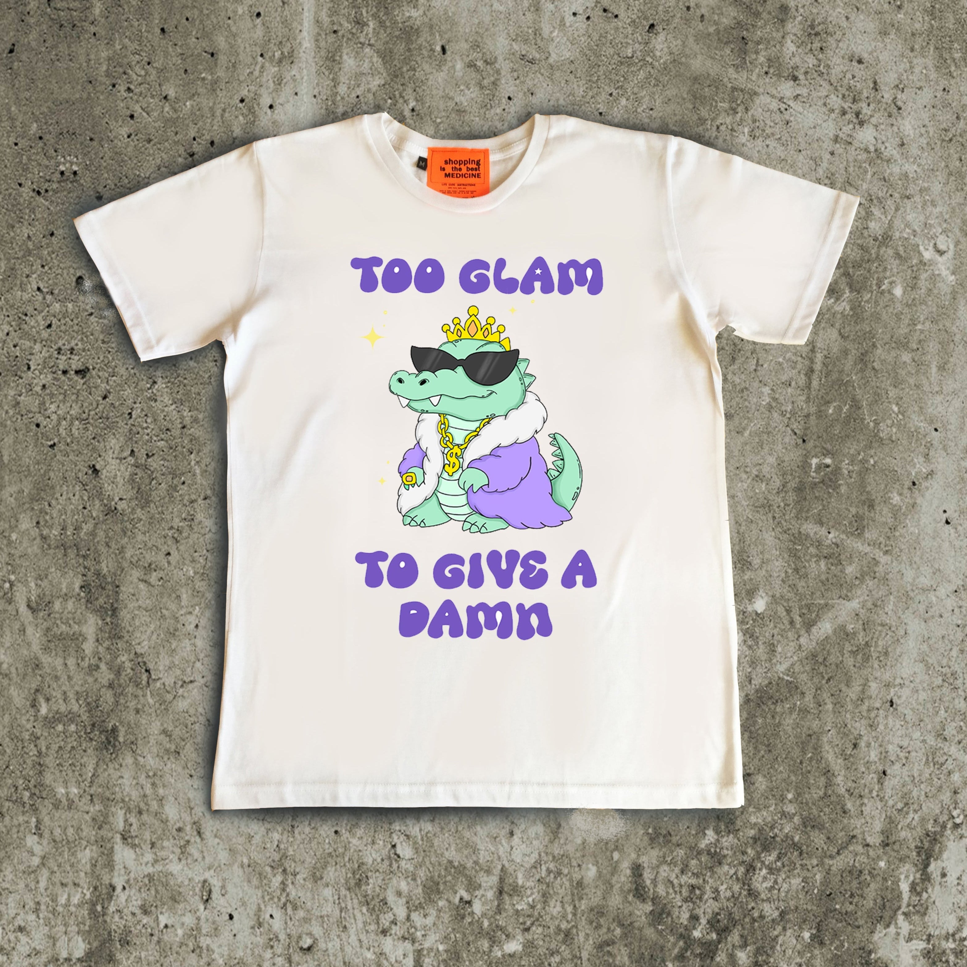 White t-shirt with a graphic of a dinosaur and text on a concrete surface