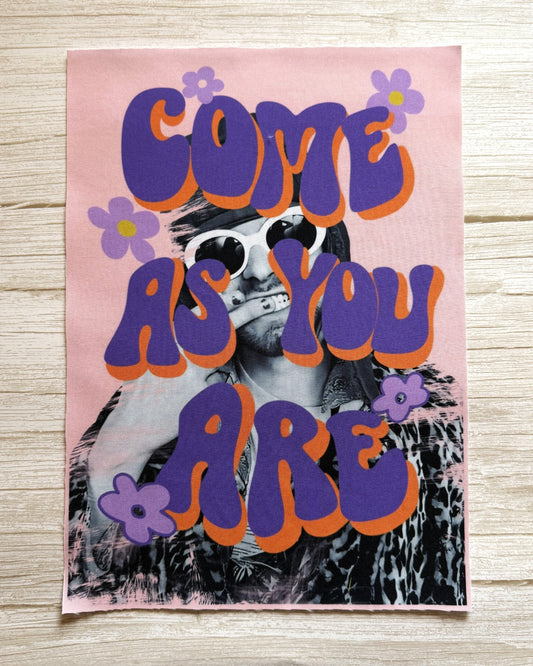 Poster with a person wearing sunglasses and text 'COME AS YOU ARE' on a pink background.