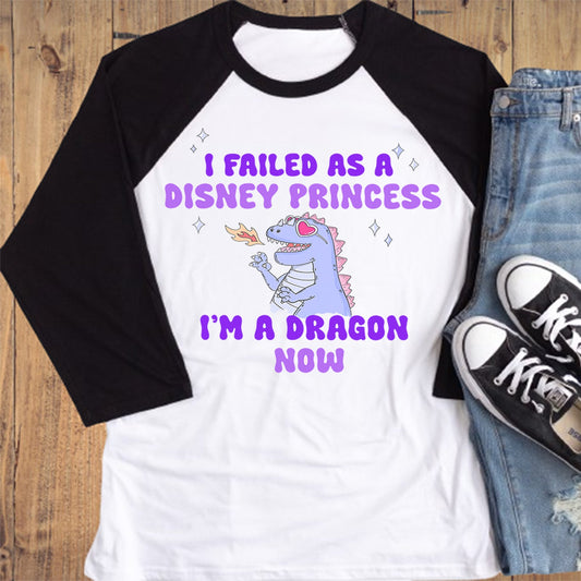 White and black baseball shirt with a graphic and text, paired with jeans and sneakers on a wooden surface.