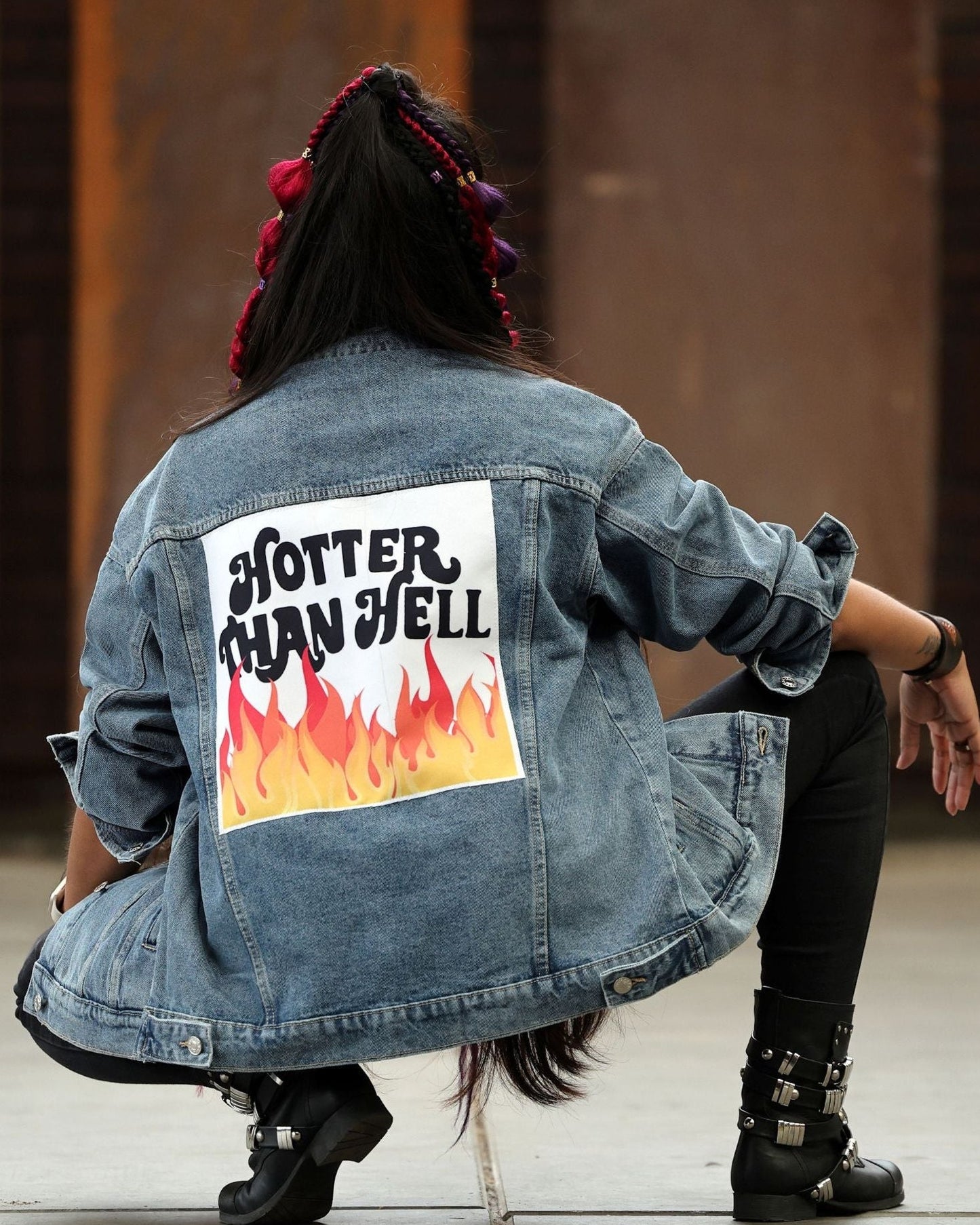 Person wearing a denim jacket with 'Hotter Than Hell' graphic on the back.