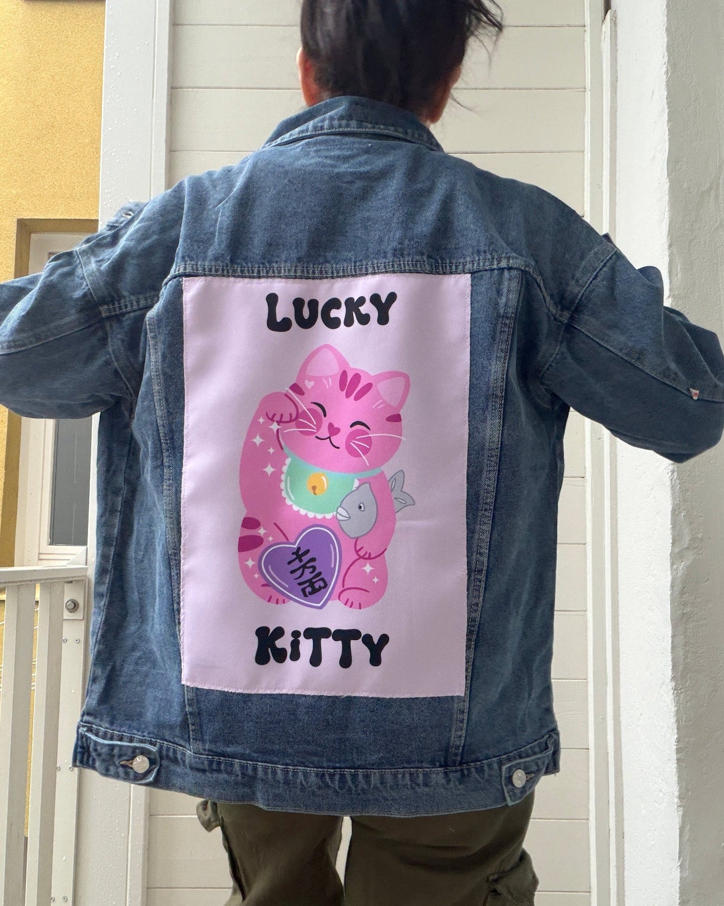 Denim jacket with a pink cartoon character and text on a white background