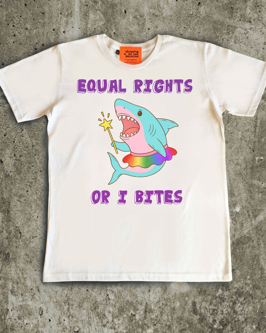 White t-shirt with a colorful shark graphic and text on a concrete surface, gay pride illustration